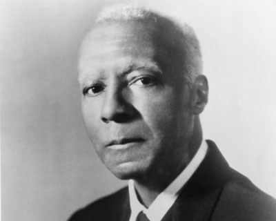 Portrait of A. Philip Randolph wearing a dark suit.