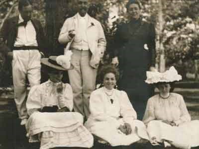 Six smartly dressed men and women posing for a photo outdoors.