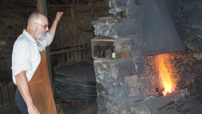 demonstrating the work of a blacksmith at Hopewell's Blacksmith shop.