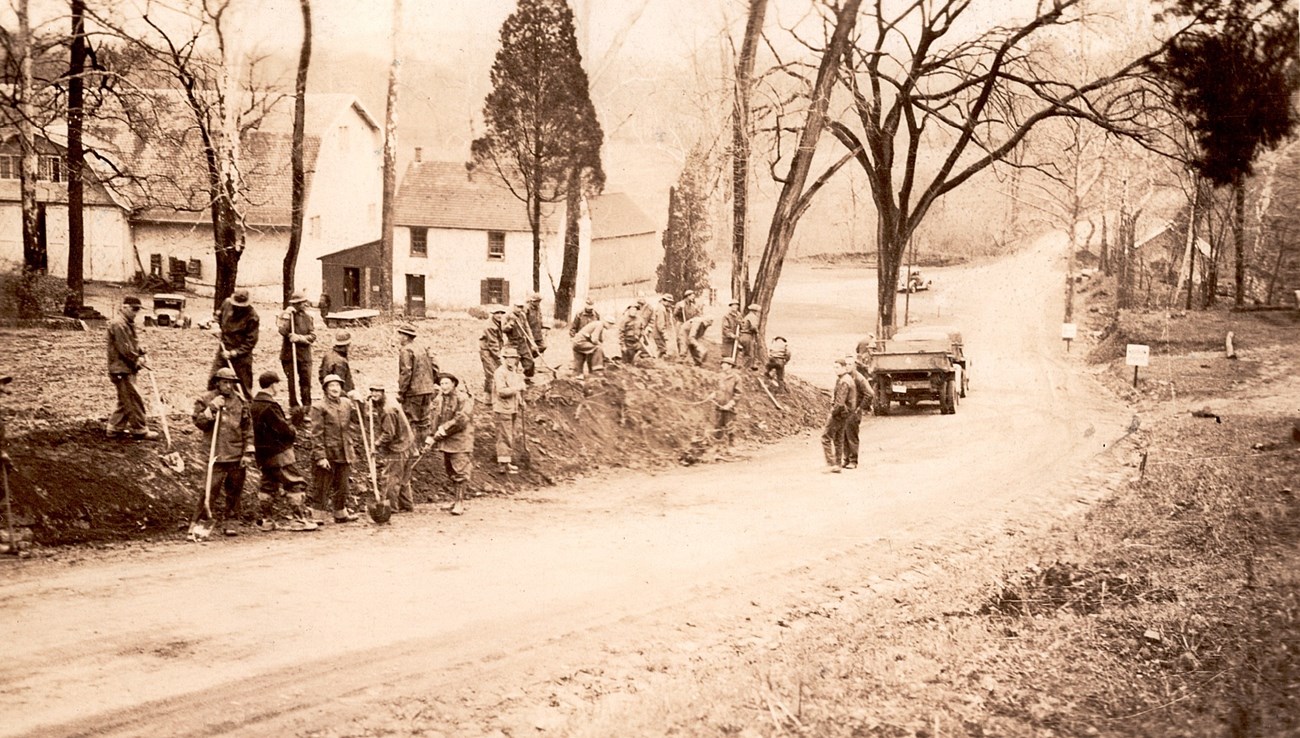 A group of people working on a sloped road.