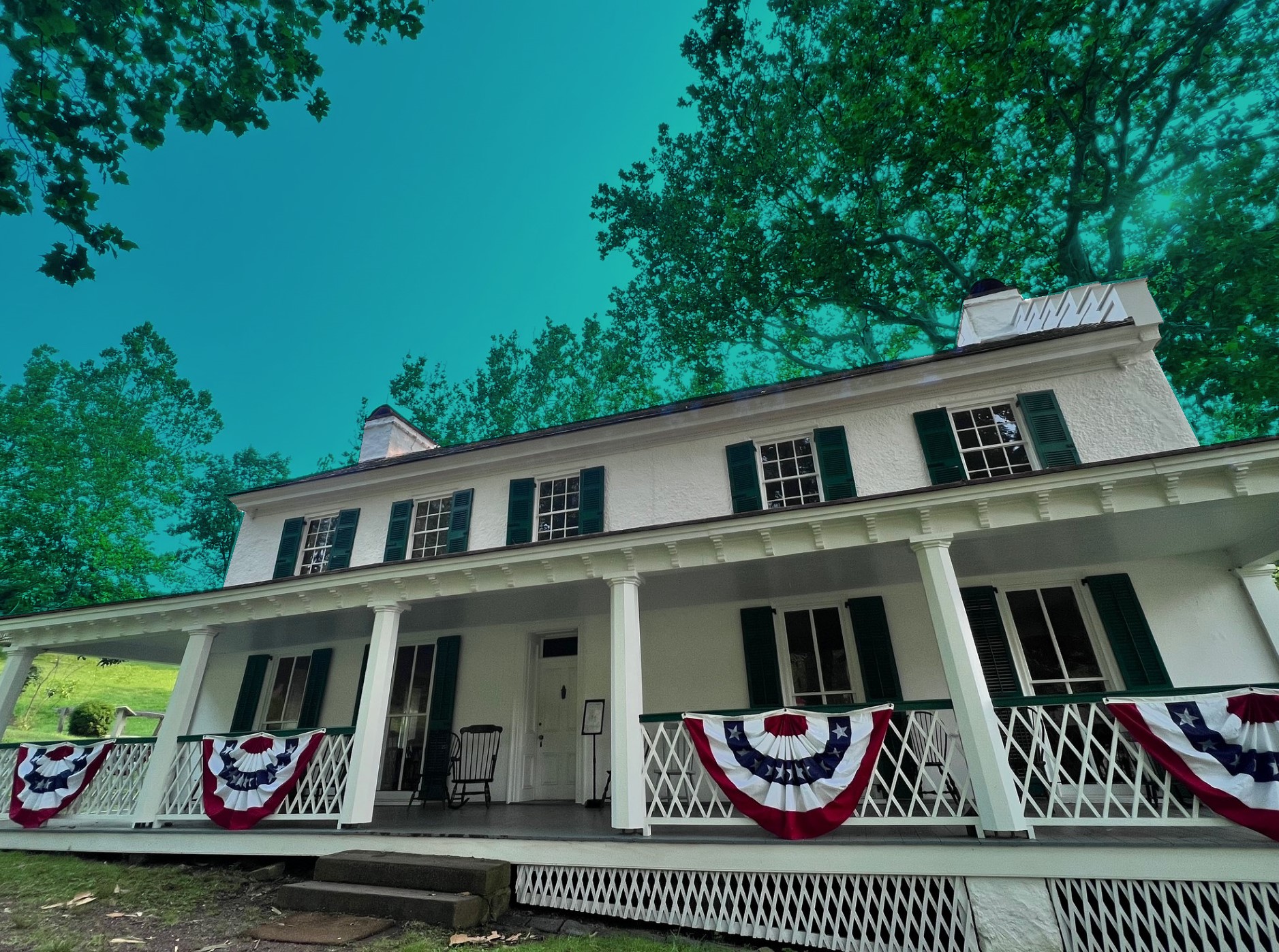 Large white house with red white and blue patriotic bunting.