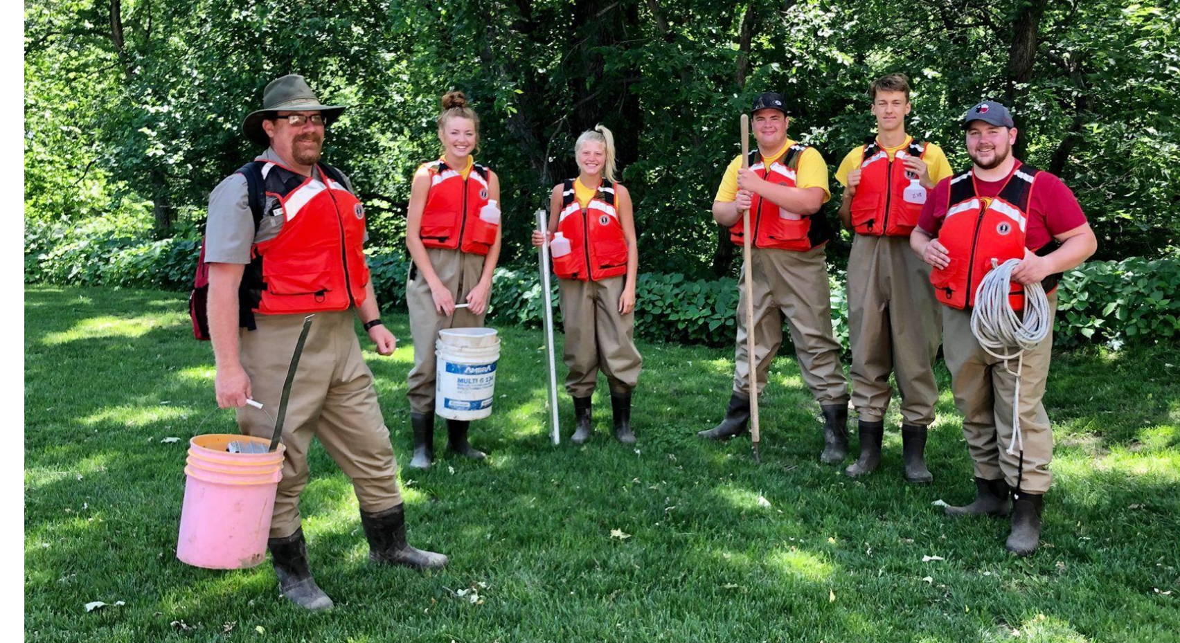 An image of six people in life jackets posing with equipment.