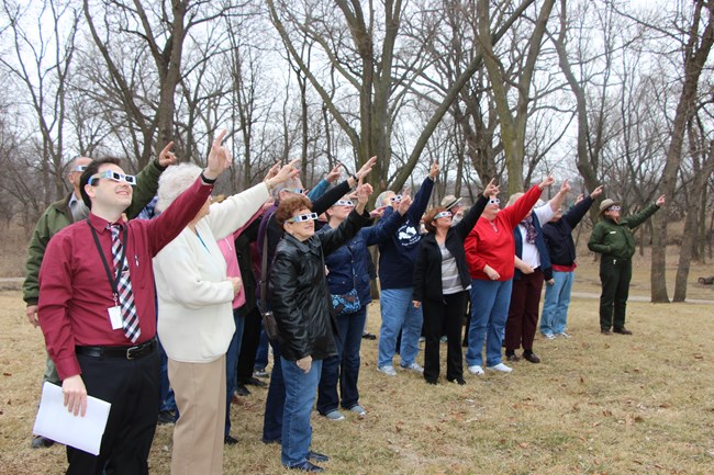 People wearing solar eclipse glasses