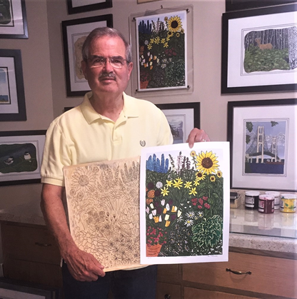 Artist-in-Residence Ben Bohnsack A man wearing a yellow shirt holds a colorful woodblock print up to the camera. It depicts plants and flowers.