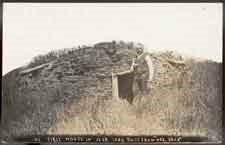 Solomon Butcher standing in front of his first Nebraska house