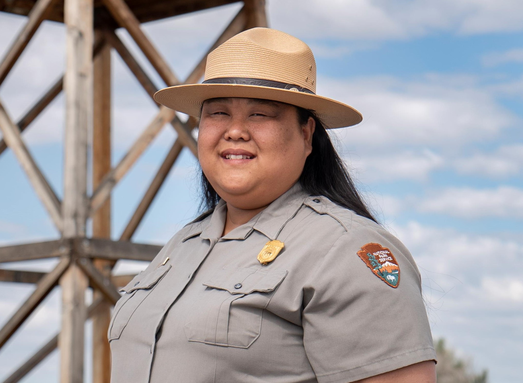 Hanako Wakatsuki in NPS uniform standing in front of a wooden guard tower.