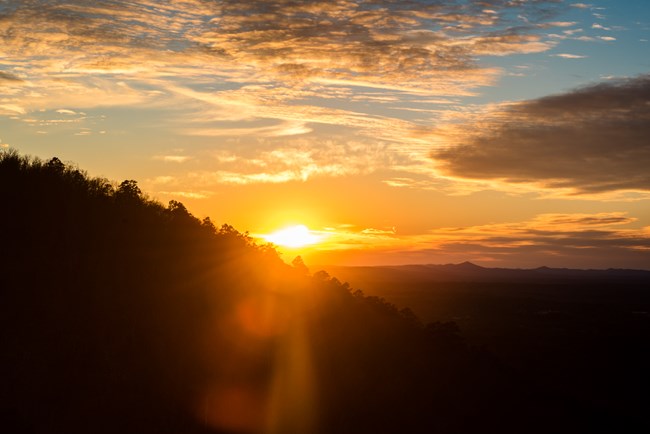 Sun setting behind mountain