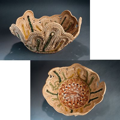 side view and top view of basket. Center is ceramic base of rust and clay color. Woven seagrass primarily natural color with areas of green extending upward.