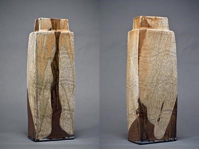 Hand-built wood-fired stoneware with neutral to rust orange to brown colors of glaze. It is a tall vase-like sculpture.