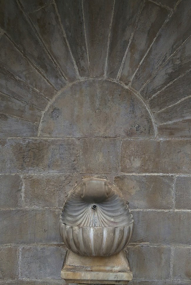 Fountain in the shape of a shell incased in a concrete staircase