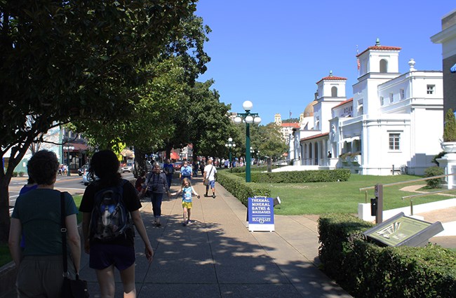 Visitors enjoying a shady stroll on the Magnolia Promenade along historic Bathhouse Row in Hot Springs National Park Visitors enjoying a shady stroll on the Magnolia Promenade along historic Bathhouse Row in Hot Springs National Park