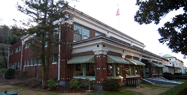 Superior Bathhouse Two story, red brick Superior Bathhouse. Building has large windows on the first floor that are shaded by green and white awnings.