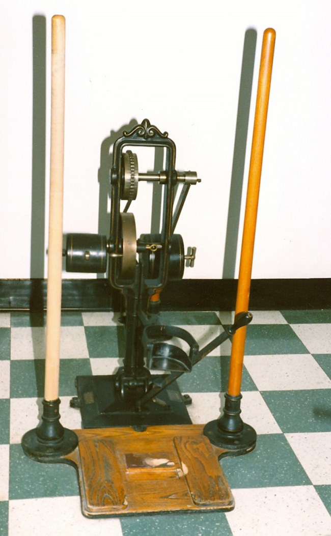 A machine for arm strengthening and chest enlarging, vertical bars with weights and pullies.