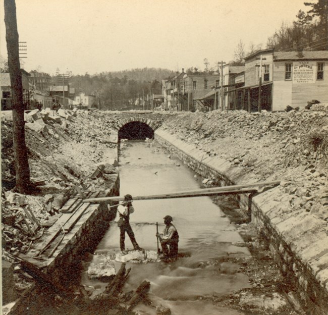 Men constructing the brick archway over Hot Springs Creek