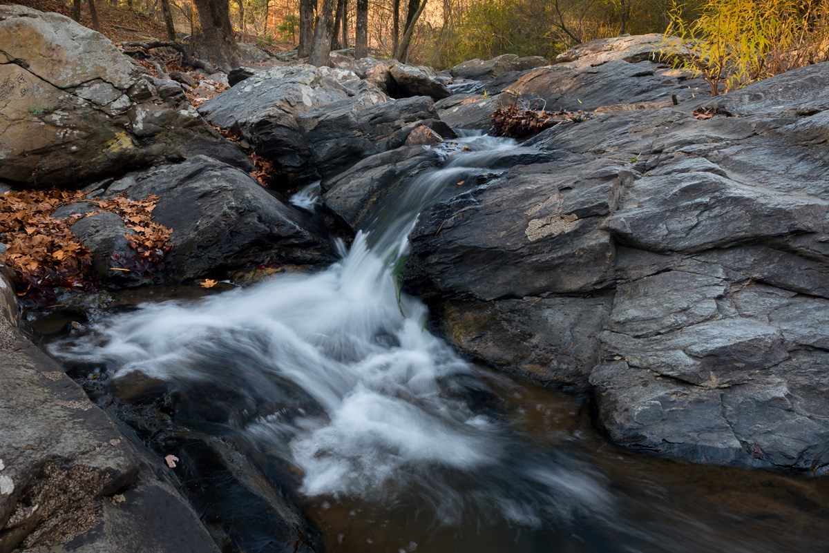 Water rushes over boulders in the middle of Gulpha Creek