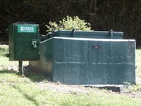 green concrete box with metal lid painted green with smaller US Geological Survey monitoring device to the left; the number 49 is on a plate on the front of the large box green concrete box with metal lid painted green with smaller US Geological Survey monitoring device to the left; the number 49 is on a plate on the front of the large box