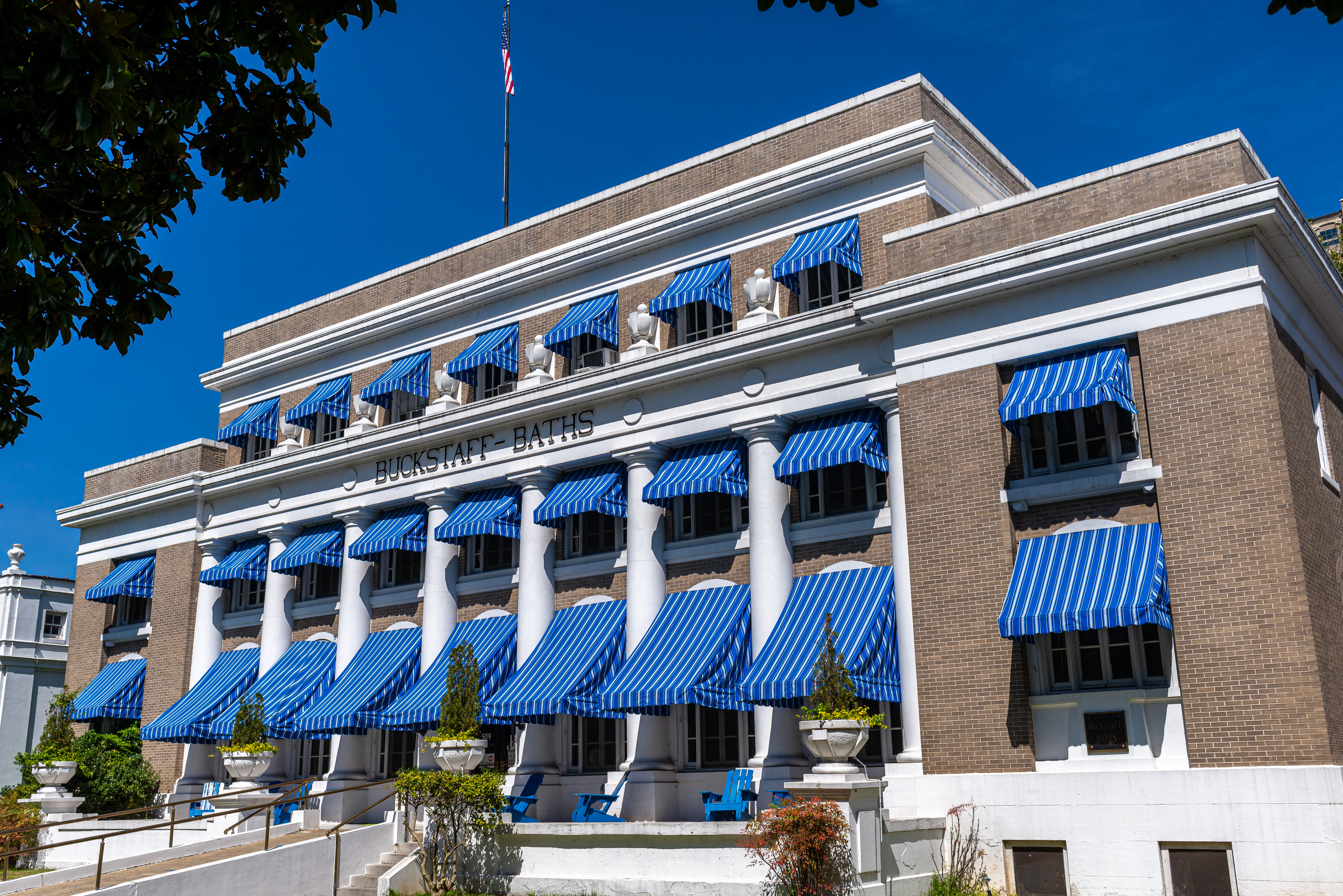 Multistory brick building with blue awnings.