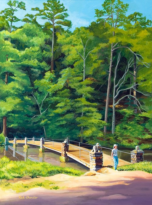 Vertical painting of Stonebridge with trees in the background on the far side of the bridge and a woman standing at the near end of the bridge facing as if she just walked across it; foreground is bare with shadows.