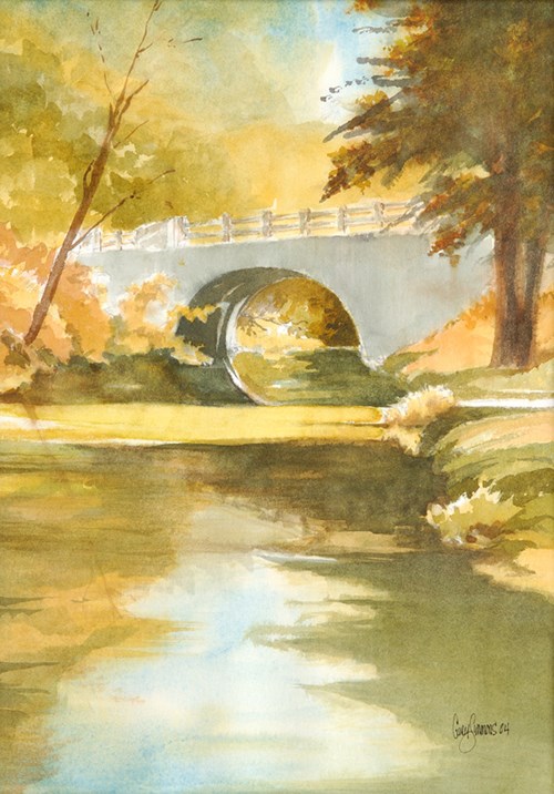 watercolor painting with creek in foreground, reflecting blue sky in center and orange leaves on left and shadows on right, center of picture is a light gray half moon bridge with trees on either side
