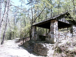early spring scene of graveled trail on the left and stone trail shelter on the right. early spring scene of graveled trail on the left and stone trail shelter on the right.