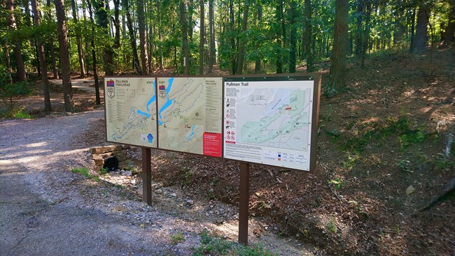NPS sign for the Pullman trail with a map and information. There are two more signs showing the City's Mountain Bike trails and how they connect to Pullman.