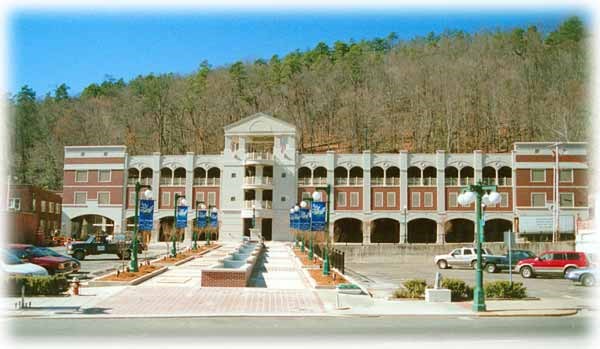 Long sidewalk with a central fountain cascade leads to the 4 story parking garage
