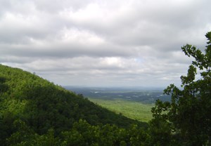 beautiful view from West Mountain showing portion of hillside on the left, trees on the right, with a gray overcast sky and green valley below beautiful view from West Mountain showing portion of hillside on the left, trees on the right, with a gray overcast sky and green valley below