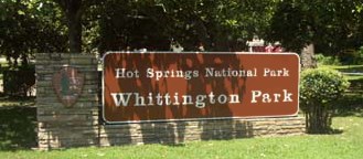color photo of Whittington Park sign, redwood colored with white lettering, mounted on stone base with NPS arrowhead on left color photo of Whittington Park sign, redwood colored with white lettering, mounted on stone base with NPS arrowhead on left