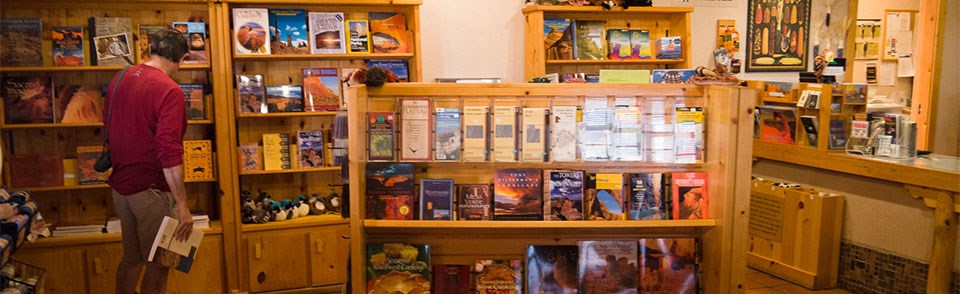 A man stands in front of bookshelves