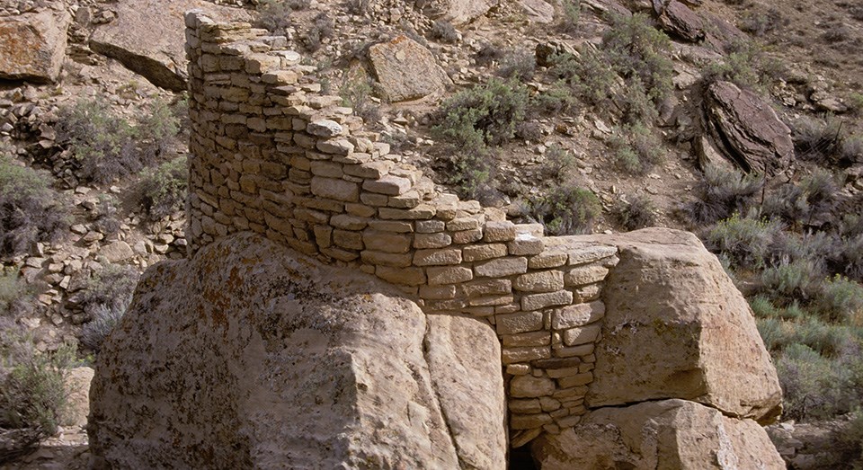 a round structure built against three large boulders a round structure built against three large boulders