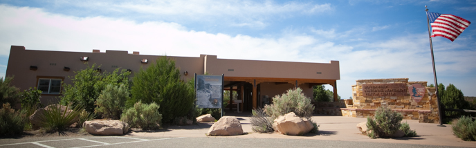 A visitor center with American flag flying outside. A visitor center with American flag flying outside.