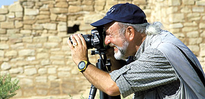 Visitor peering into a camera lens on a tripod Visitor peering into a camera lens on a tripod