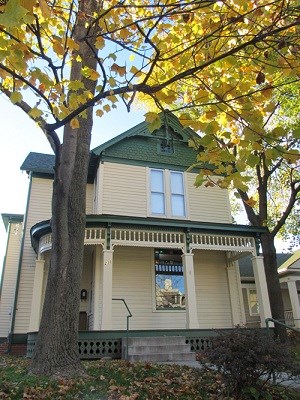 A pale yellow house with a large columned front porch.