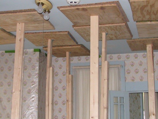 Shoring installed in second floor bedroom during ceiling plaster stabilization.