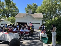 A group of young new citizens stand with their right hands raised, families nearby, with the American flag close. President Truman