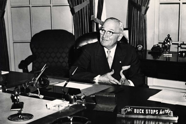 Your Buck Stops Here President Truman proudly showing off the famous sign on his desk.