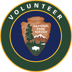 Green and brown circular logo with NPS arrowhead and "Volunteer" in white leadering at the top.