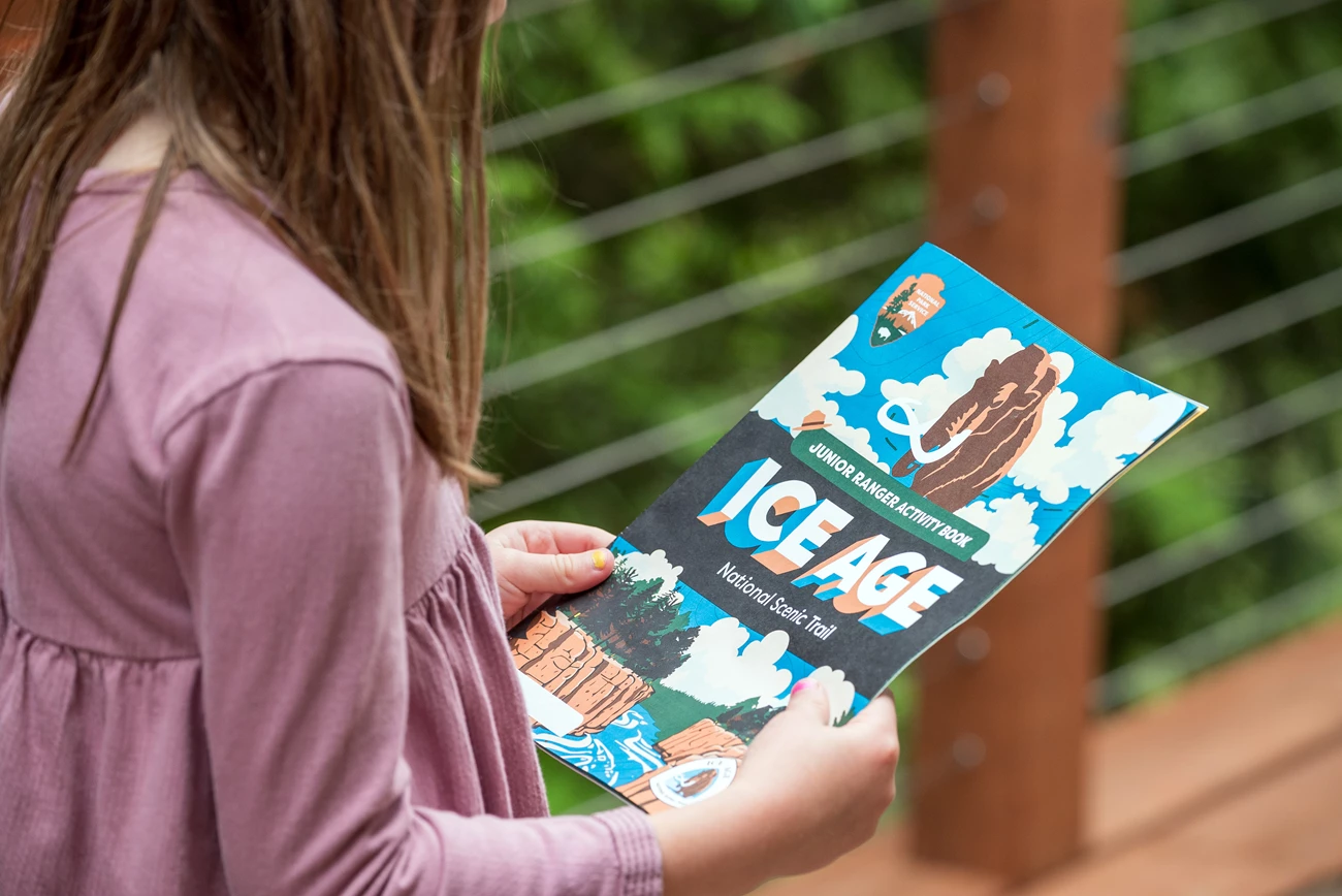 IATR Junior Ranger Activity Booklet Kids Holding Photograph of child holding junior ranger booklet.