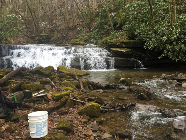 Keeney Creek waterfall, with sampling equipment arranged on the rocks in the foreground