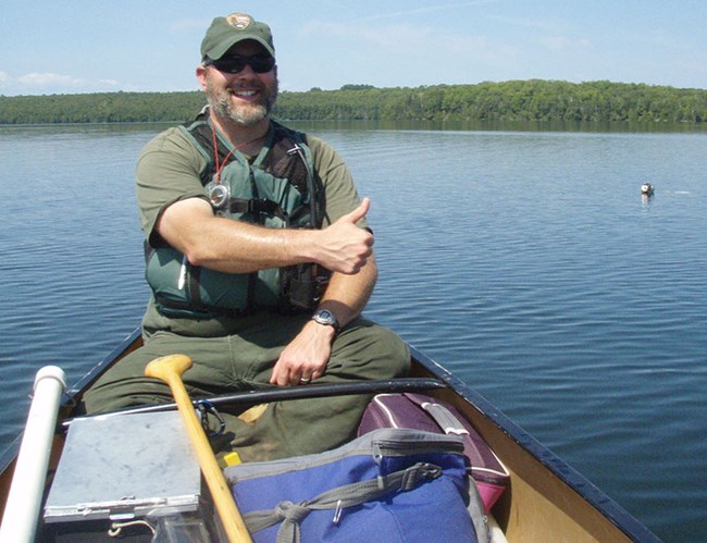 a man in a canoe wearing sunglasses
