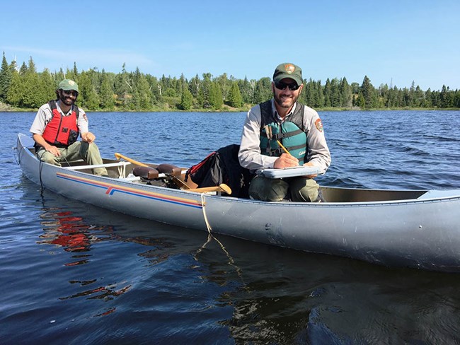 Collecting water quality data Two biologists in a canoe on a large lake