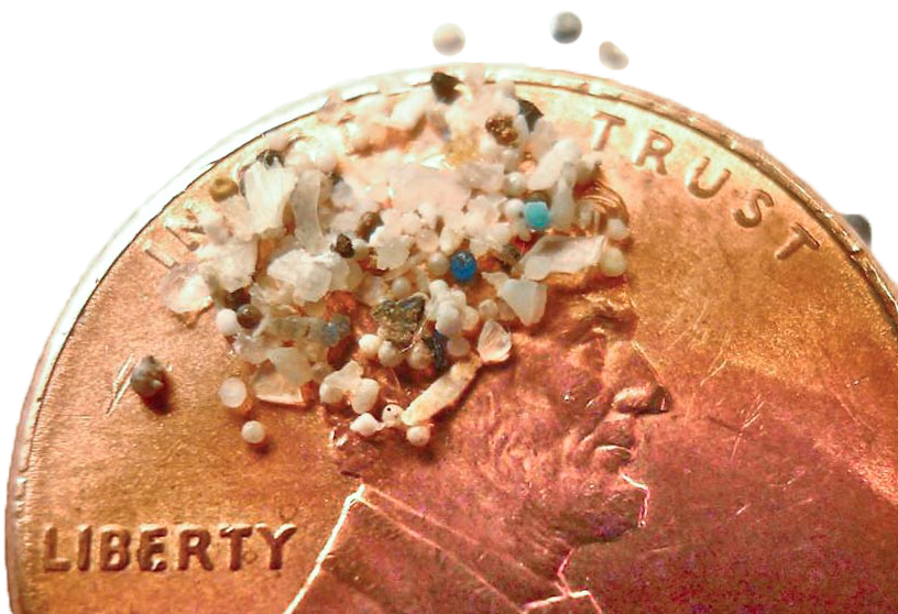 Microplastics scattered on part of a penny