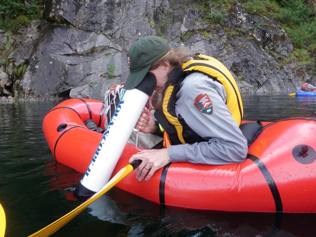 Monitoring aquatic vegetation in Kenai Fjords National Park National Park Service scientist in a raft using a scope to see under water
