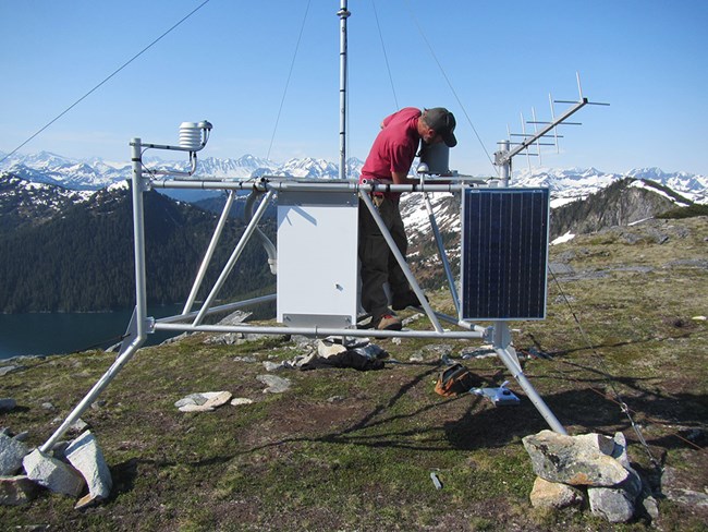 A researcher works on a weather station.