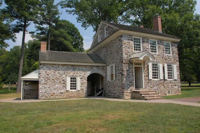 Washington's Headquarters Two-story historic stone house with white trim, surrounded by grass and some trees