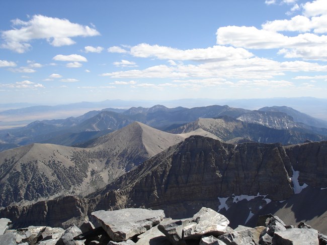 Jagged mountain summits below a cloud filled sky.