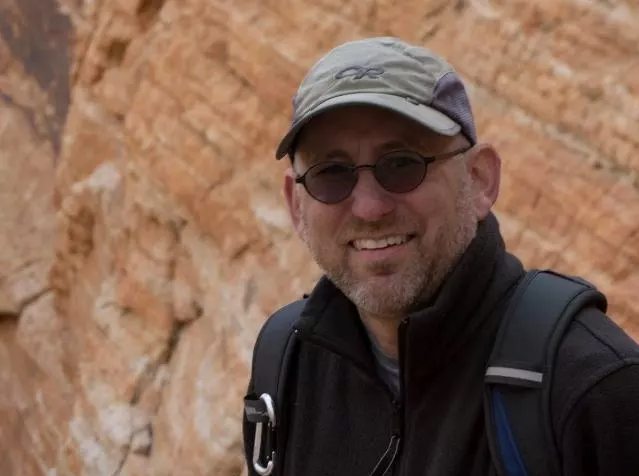 Mark Lehman, Data Manager Smiling man in baseball cap and dark glasses with sandstone formation behind him