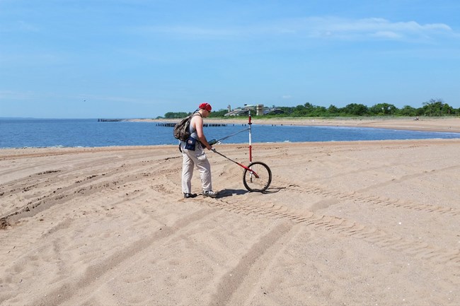 Shoreline data at GATE Researcher rolling GPS contraption along beach