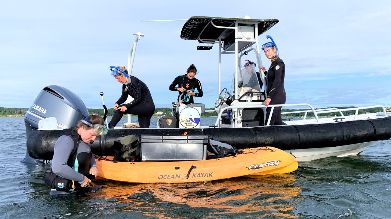 Five researchers getting ready on a boat in an estuary