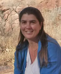 Woman with red soil in background